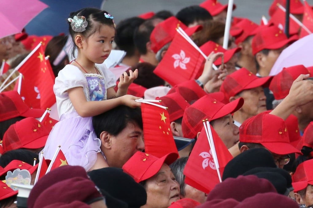 People in Hong Kong watch the flag-raising ceremony at the Golden Bauhinia Square in Wan Chai on July 1, to mark the 21st anniversary of the establishment of the Hong Kong Special Administrative Region. Photo: David Wong