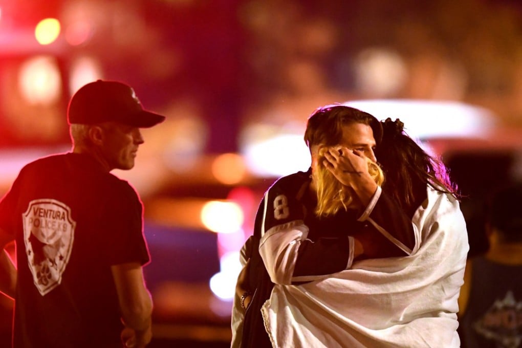 People comfort each other after a mass shooting at the Borderline Bar and Grill in Thousand Oaks late Wednesday night. Photo: TNS