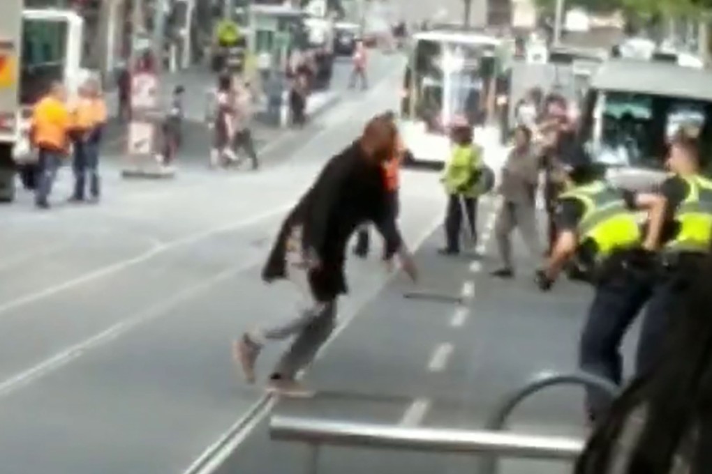 A video grab of a man fighting with policemen in downtown Melbourne after he stabbed a number of people on November 9, 2018. Photo: Chris Newport via Instagram/AFP