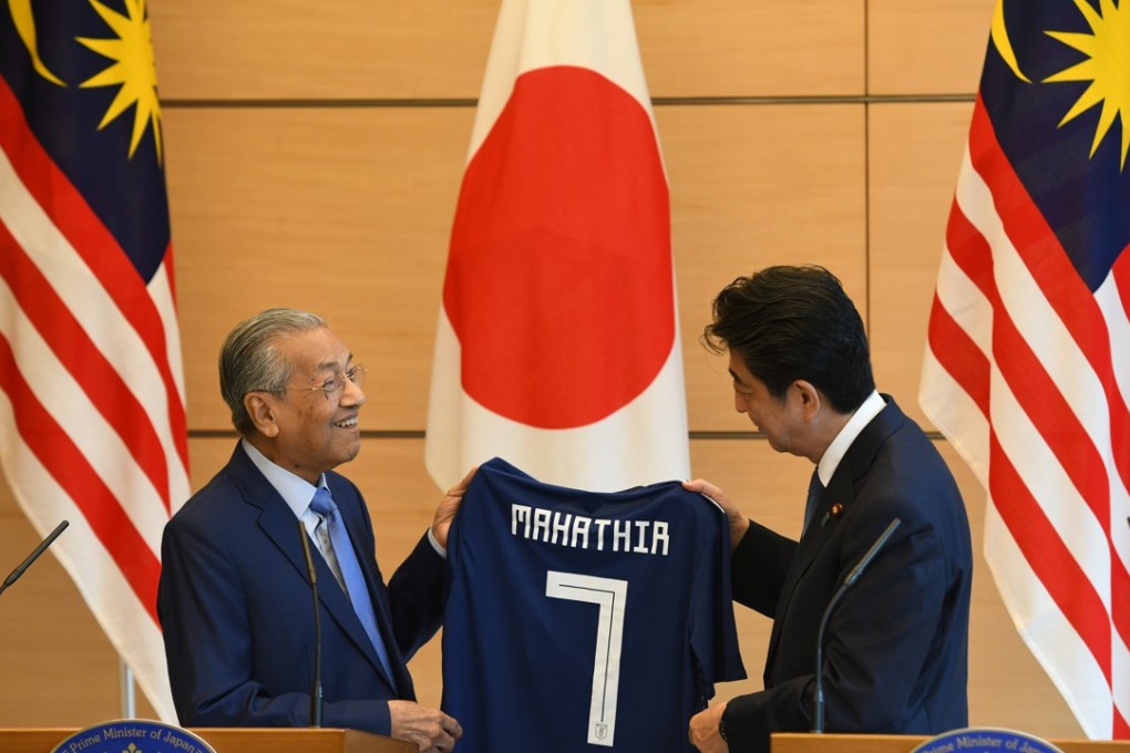 Malaysian Prime Minister Mahathir Mohamad (L) receiving a Japanese national football jersey from his Japanese counterpart Shinzo Abe (R) during their joint press remarks at Abe's official residence in Tokyo on 12 June 2018. Photo: EPA