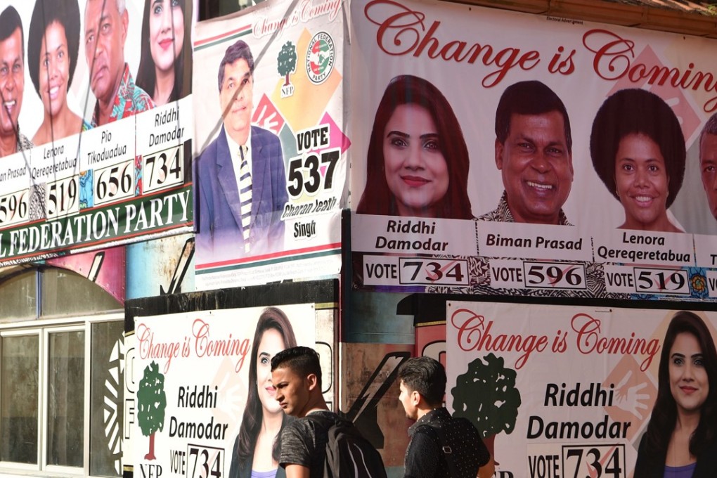 People walking past election posters in the Fijian capital Suva. Photo: AFP