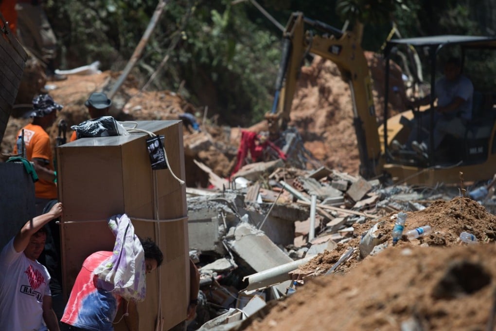 Residents and volunteers work to save animals and belongings in the area affected by a landslide. Photo: AFP