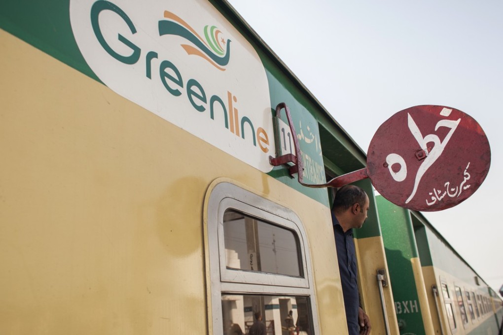 A passenger looks out from a coach door of a Green Line Express train sitting at Khanewal Junction railway station in Khanewal, Punjab, Pakistan, on February 20, 2018. Beijing is set to upgrade a 1,163-mile track from Karachi to Peshawar near the Afghan border with an $8 billion loan to Pakistan as part of Chinese President Xi Jinping's Belt and Road trade initiative, Photo: Bloomberg