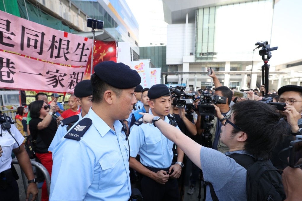 Rival groups of protesters are separated by police outside Tung Chung’s Citygate outlet mall. Photo: Winson Wong