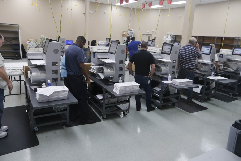 Elections staff load ballots into machine as recounting begins at the Broward County Supervisor of Elections Office on Sunday in Lauderhill, Florida. Photo: AFP