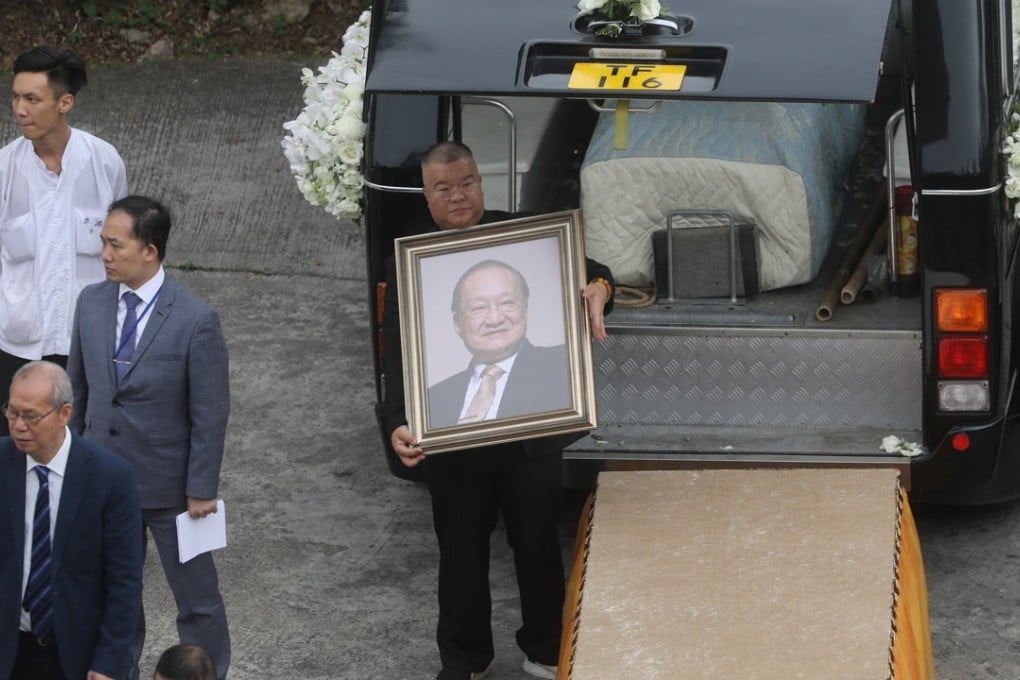 Andrew Cha holds a portrait of his father Louis Cha, as the funeral cortege arrives at Po Lin Monastery, Lantau Island. Photo: Sam Tsang