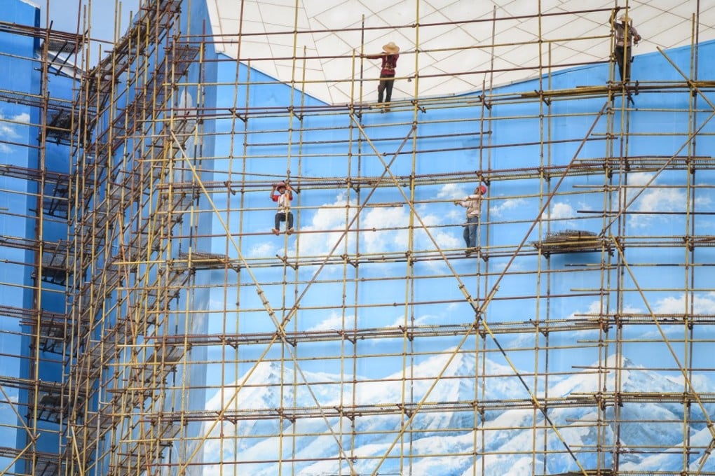 Workers climb scaffolding outside a building in Haikou, Hainan. While there is no doubt that the US has contributed to China’s economic development, the overstretched claim that America rebuilt China can be refuted on many fronts. Photo: AFP