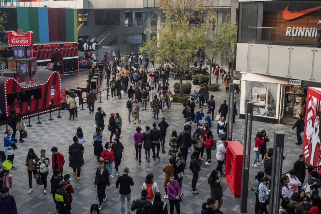 Shoppers walk past stores in Beijing on November 3. Chinese retail sales slowed to 8.6 per cent in October from a year earlier as consumers reined in their spending. Photo: Bloomberg