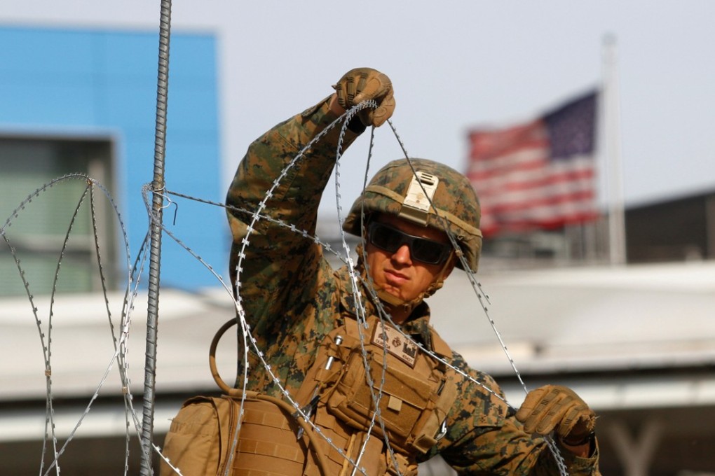 A US Marine sets up a barricade with concertina wire, at the border between Mexico and the US, in preparation for the arrival of migrants, in Tijuana, Mexico. Photo: Reuters