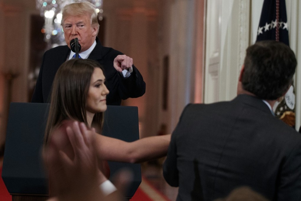 US President Donald Trump watches as a White House aide reaches to take away a microphone from Jim Acosta of CNN during a news conference in Washington on November 7. CNN is suing the Trump administration, demanding that Acosta’s press credentials to cover the White House be restored. Photo: AP