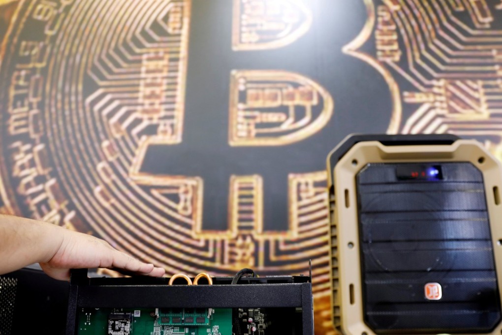 FILE PHOTO: A cryptocurrency mining computer is seen in front of bitcoin logo during the annual Computex computer exhibition in Taipei, Taiwan, June 5, 2018. REUTERS/Tyrone Siu/File Photo