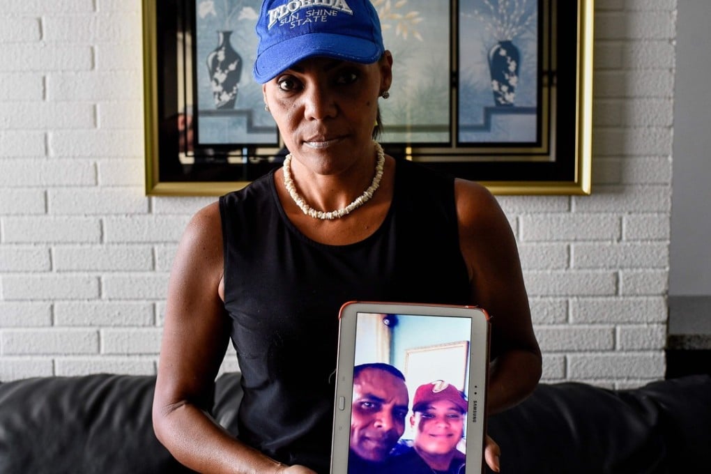 Venezuelan Yamileth Marcano, 46, shows picture of her brother, who was killed as he was robbed of his phone. Photo: AFP