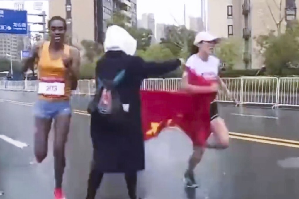 The race volunteer presses the flag into He Yinli’s hands.Photo: sina.com.cn