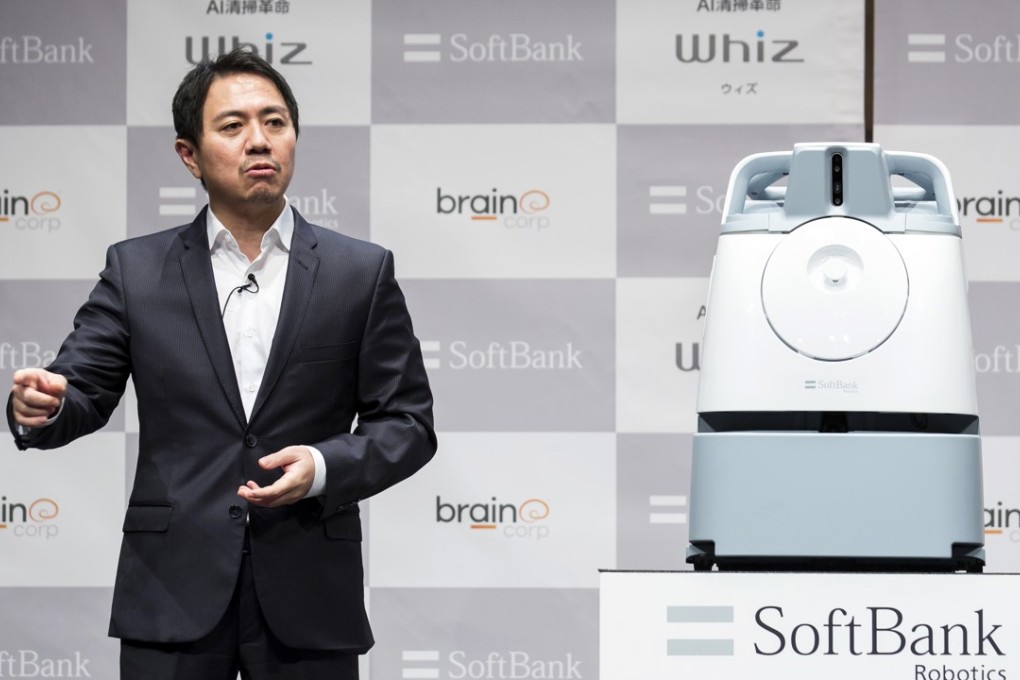 Fumihide Tomizawa, president and chief executive of SoftBank Robotics, speaks while standing next to the Whiz autonomous floor-cleaning machine during a news conference in Tokyo, Japan, on Monday. Photo: Bloomberg