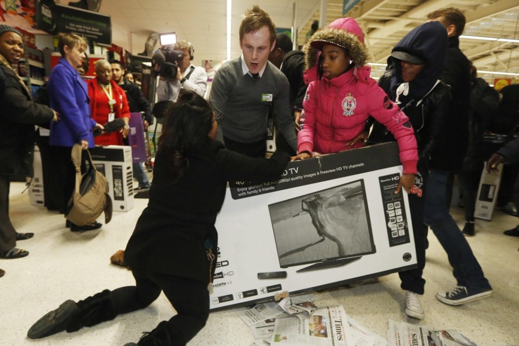 Shoppers wrestle over a television on ‘Black Friday’ at Asda in Wembley, north London on November 28, 2014. Photo: Reuters