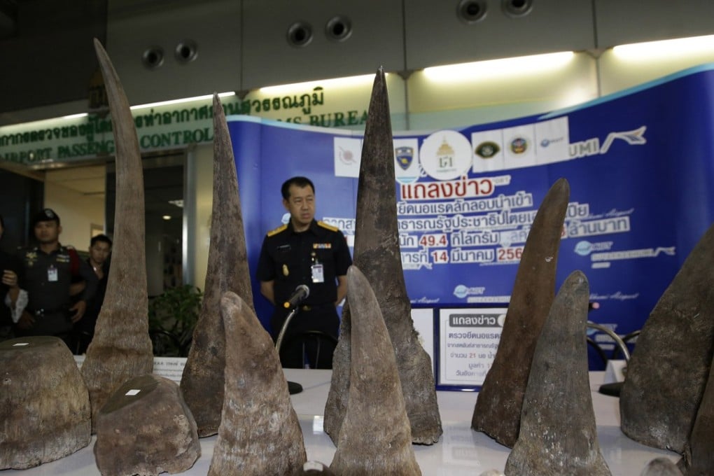 Thai customs officers stand behind the seized rhino horns. Photo: AP