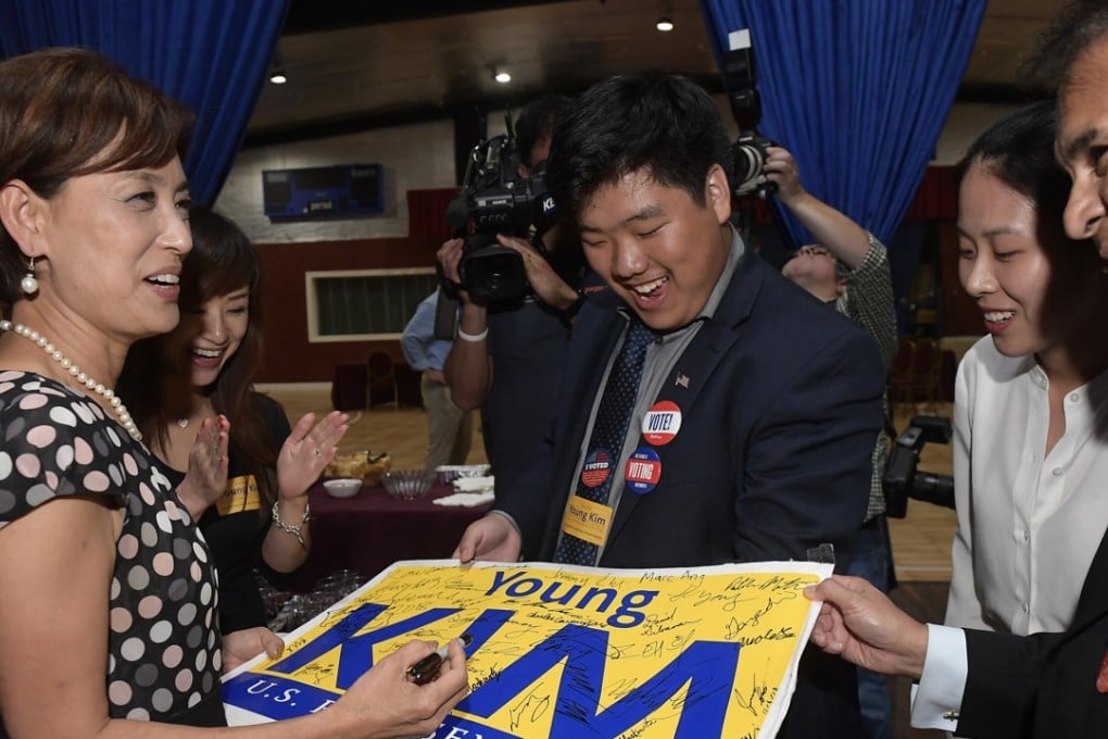 Young Kim, Republican candidate for the 39th Congressional District in California, autographing a campaign sign at a post-midnight appearance at her election-night party in Los Angeles early on Wednesday. Photo: AP