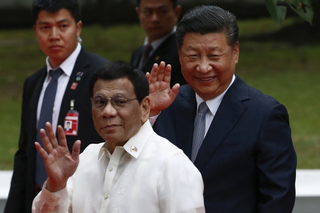 Rodrigo Duterte and Xi Jinping wave during a welcome ceremony at Malacanang Palace in Manila on Tuesday. Photo: EPA-EFE