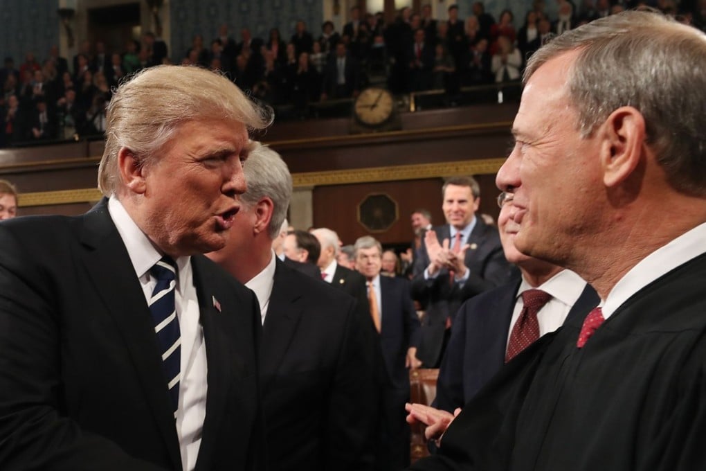 In this file photo taken on February 28, 2017, US President Donald Trump (left) shakes hands with US Supreme Court Chief Justice John Roberts Jnr as Trump arrives to deliver his first address to a joint session of Congress in Washington. Photo: Agence France-Presse