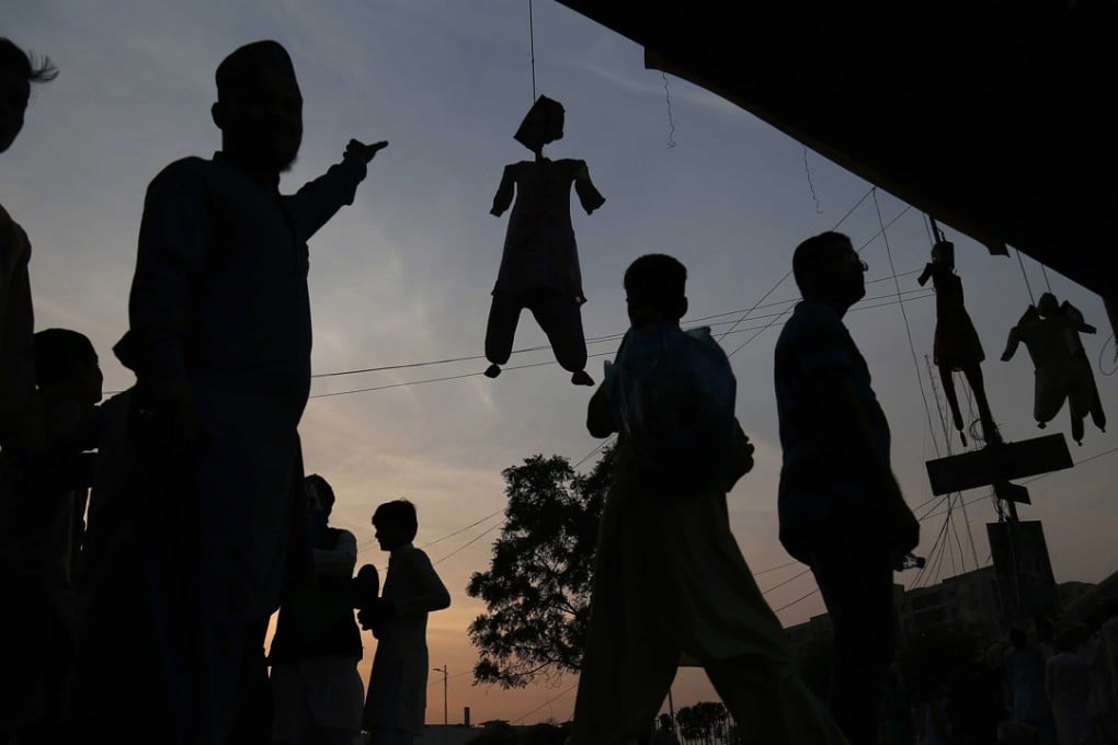 Protesters hang effigies of Asia Bibi, a Christian accused of blasphemy, during a rally to mark the Prophet Muhammad's birth anniversary, in Karachi, Pakistan, on Wednesday. Photo: EPA
