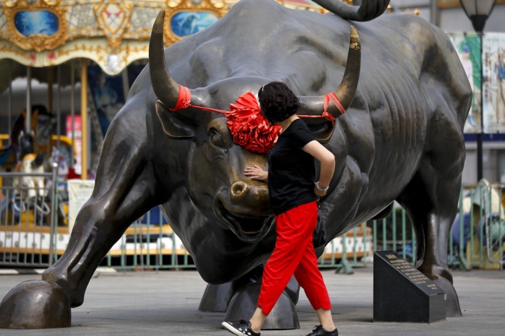 A Chinese woman touches a bull statue on display outside a mall in Beijing, in June. Data from the Institute of International Finance for the first week of November showed inflows of US$5 billion into China equities, the largest weekly total in four years. Photo: AP