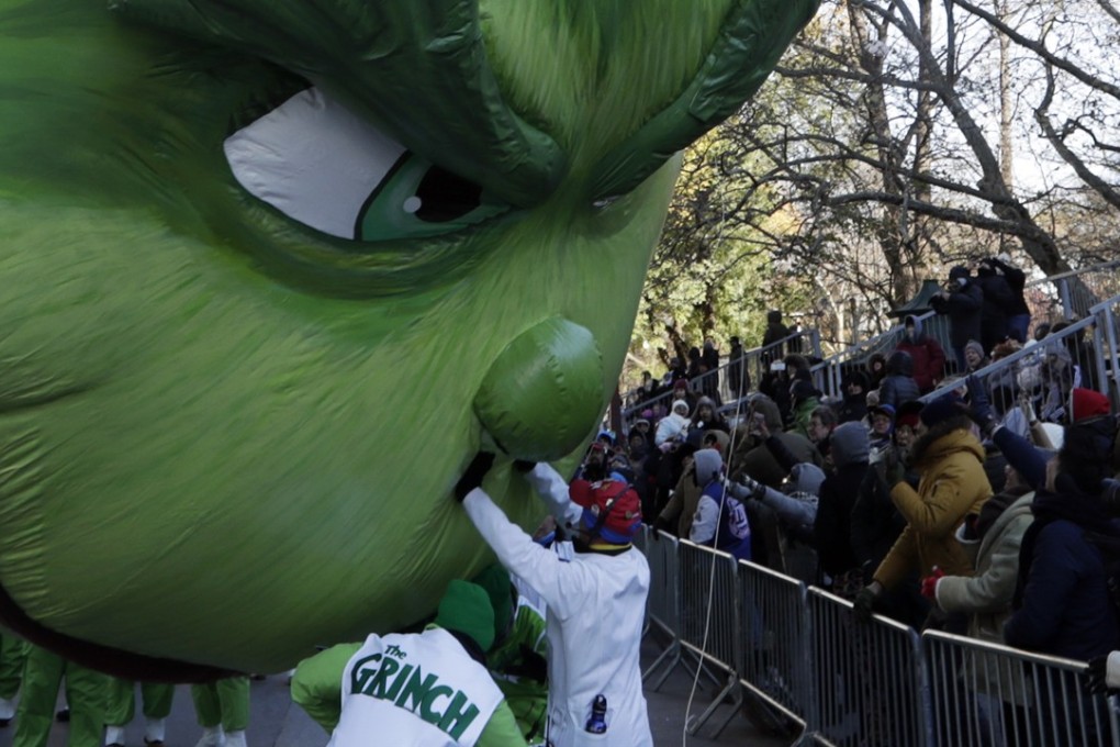 Balloon technicians try and hold back the Grinch balloon from crashing down onto the street and into the crowd as it floats down Central Park West in New York during the Macy's Thanksgiving Day Parade. Photo: EPA