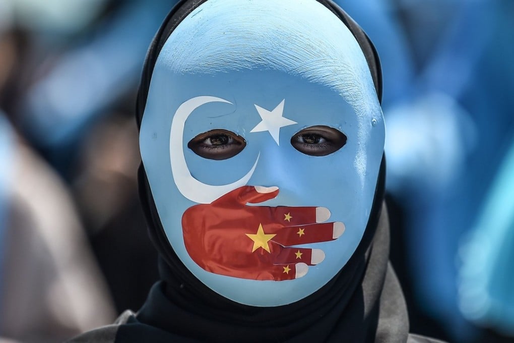A demonstrator wearing a mask painted with the colours of the flag of East Turkestan attends a protest of supporters of the mostly Muslim Uygur minority and Turkish nationalists to denounce China's treatment of ethnic Uygur Muslims. Photo: AFP