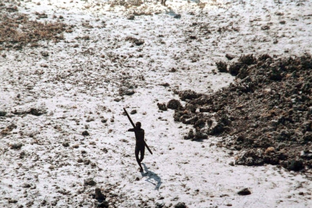 In this handout photo provided by the Indian Coast Guard and Survival International and taken on December 28, 2004, a man with the Sentinelese tribe aims his bow and arrow at an Indian Coast Guard helicopter as it flies over North Sentinel Island in the Andaman Islands, in the wake of the 2004 Indian Ocean tsunami. - Members of one of the world's last tribes untouched by modern civilisation have killed an American who ventured illegally onto their remote island, Indian police said November 22, 2018. (Photo by Handout / various sources / AFP) / -----EDITORS NOTE --- RESTRICTED TO EDITORIAL USE - MANDATORY CREDIT "AFP PHOTO / INDIAN COAST GUARD / SURVIVAL INTERNATIONAL " - NO MARKETING - NO ADVERTISING CAMPAIGNS - DISTRIBUTED AS A SERVICE TO CLIENTS