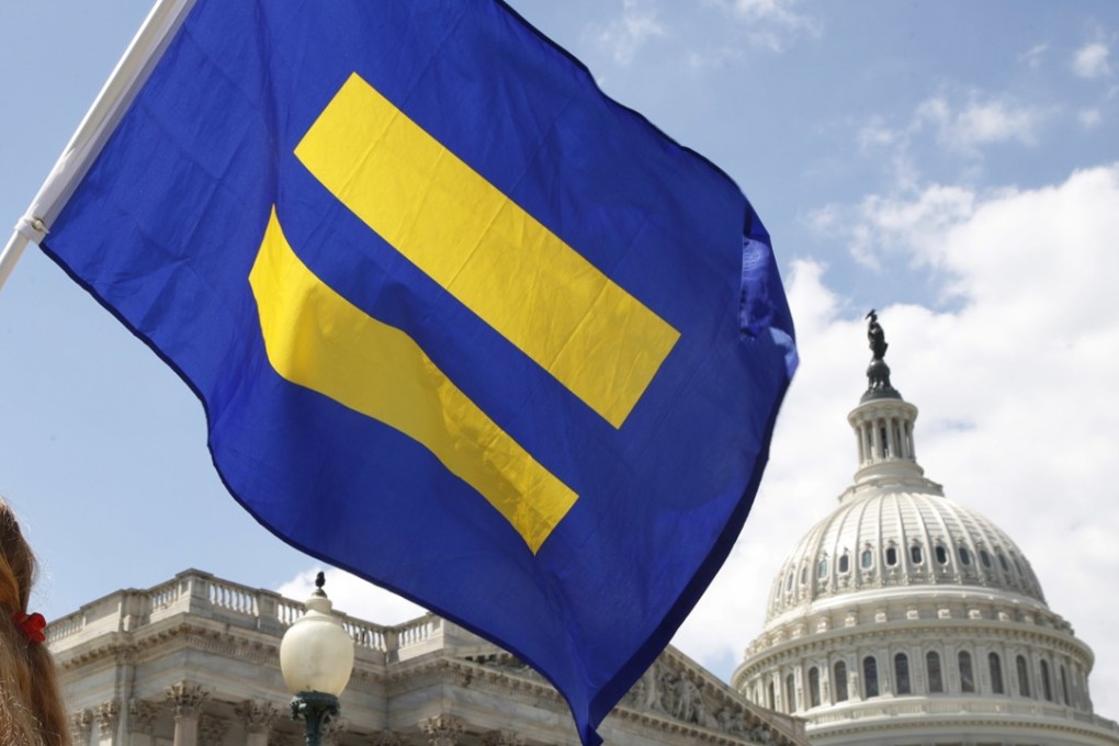 A supporter of LGBT rights holds up an “equality flag” on Capitol Hill in Washington in July 2017 in support of transgender members of the military. On Friday, the Trump administration asked the Supreme Court to fast track cases on the president's decision to prevent certain transgender people from serving in the military. Photo: AP