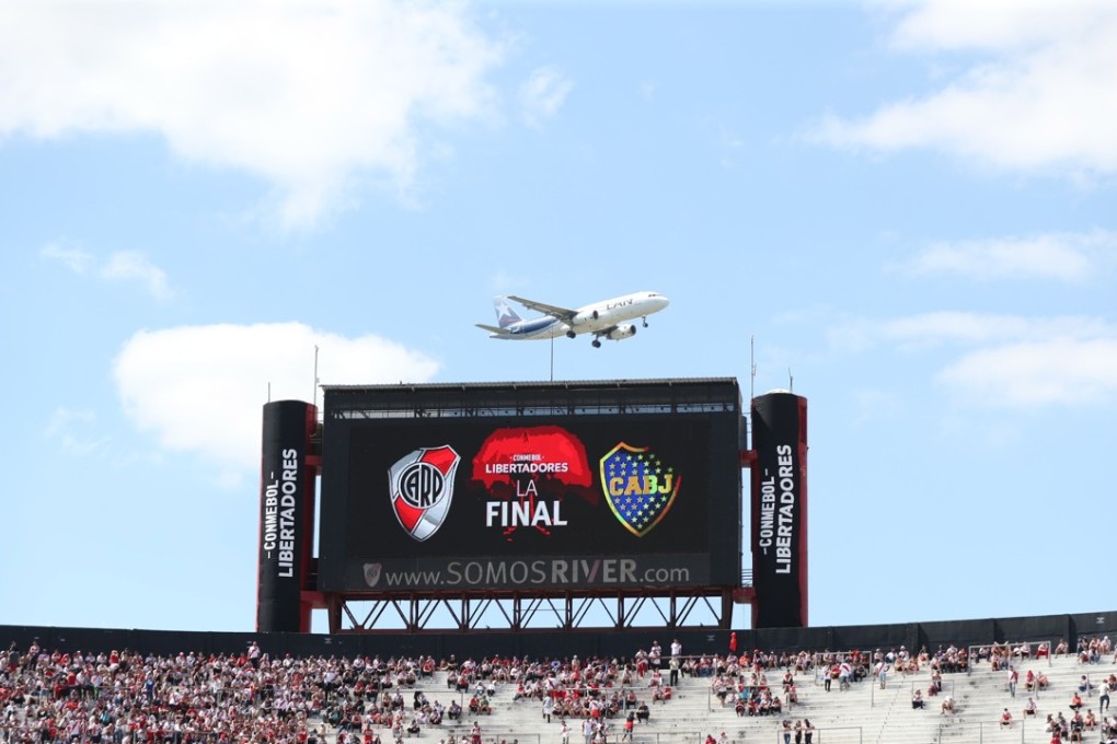 An airplane passes over the screen of the Monumental stadium. Photo: EPA