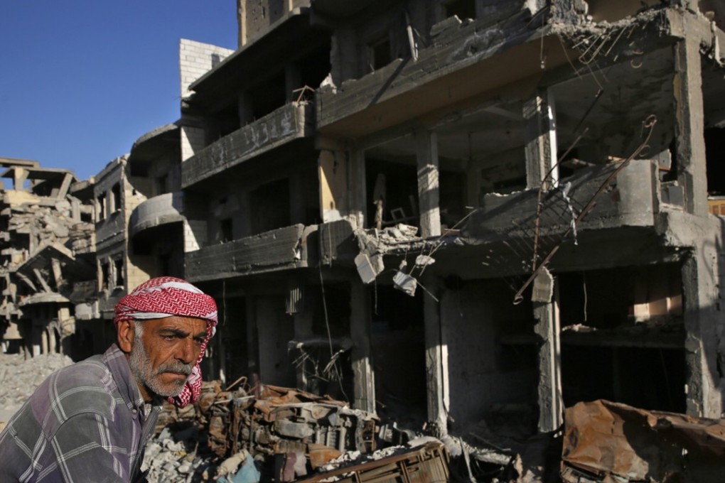 A Syrian man stands between buildings destroyed last summer during fighting between the US-backed Syrian Democratic Forces fighters and Islamic State militants, in Raqqa, Syria. Photo: AP Photo