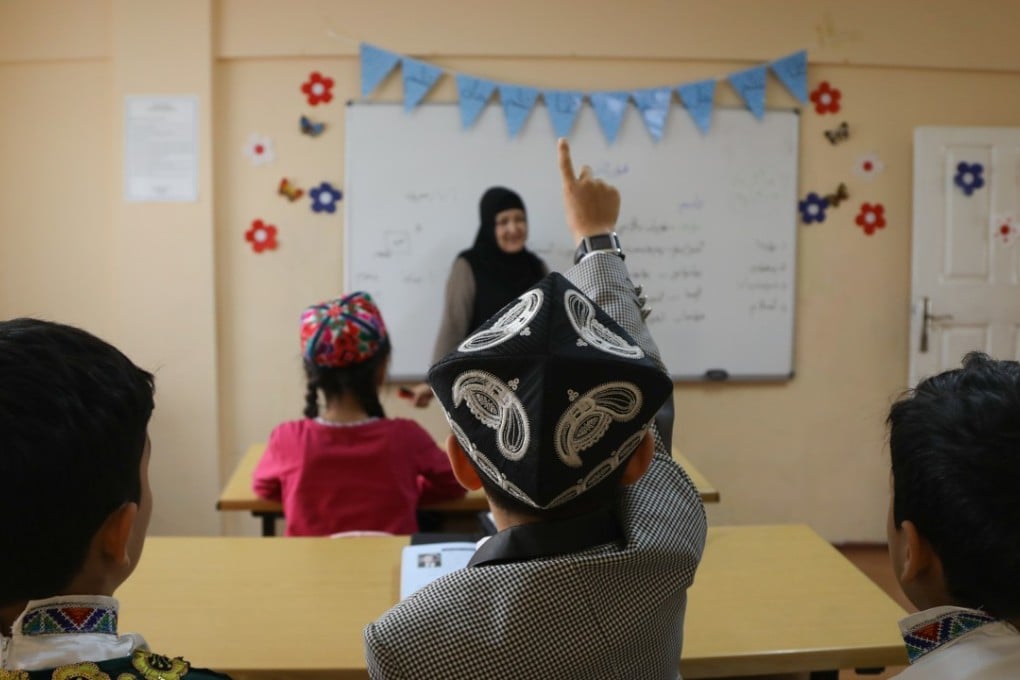 A student raises his hand in class at a Uygur school in Istanbul. Photo: Helene Franchineau