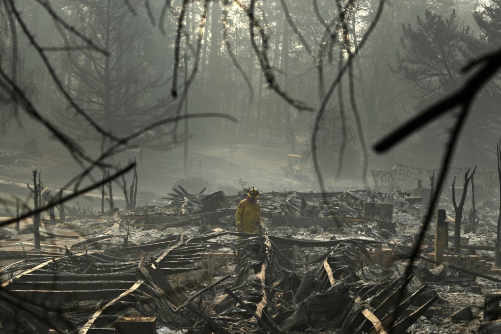 A firefighter searches for human remains in a trailer park destroyed in the Camp Fire, in Paradise, California. Photo: AP Photo