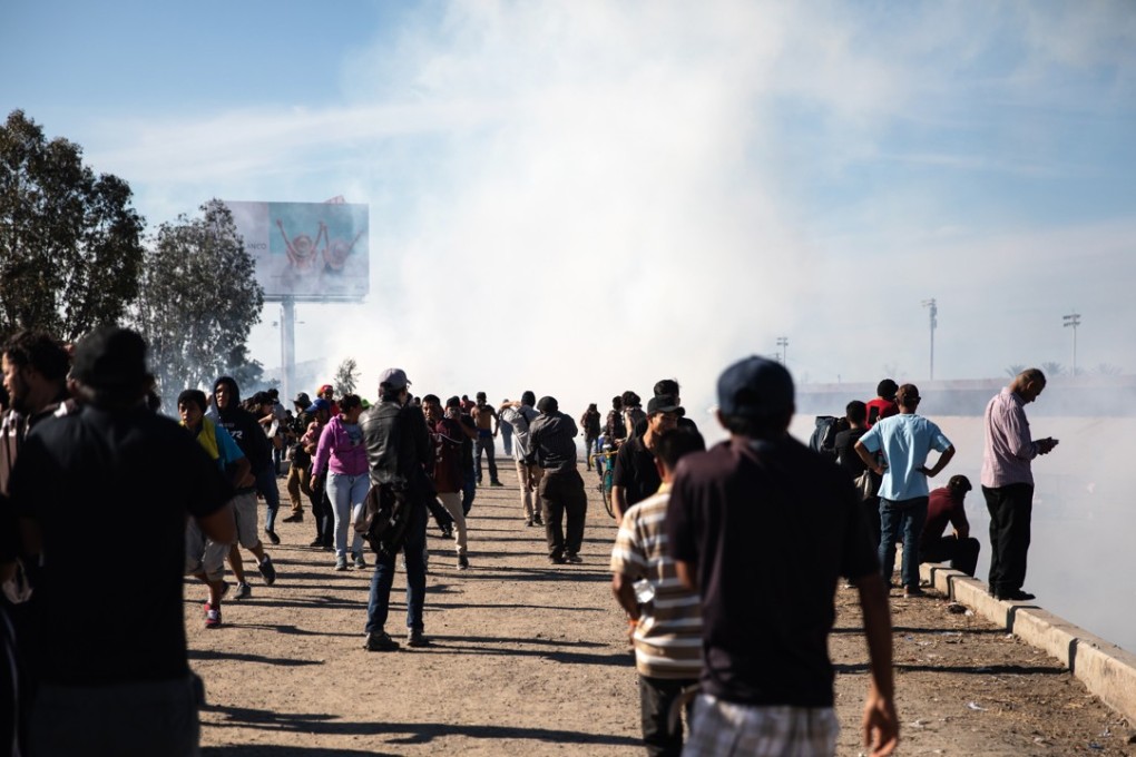 Central American migrants run away from tear gas fired from the US side of the border with Mexico on November 25, 2018. Photo: Bloomberg