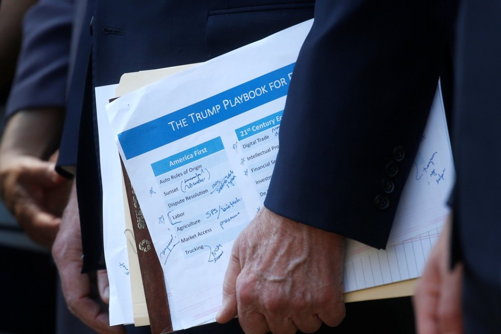 US Trade Representative Robert Lighthizer holds a “Trump Playbook” document as he stands behind US President Donald Trump at a White House news conference. Photo: Reuters