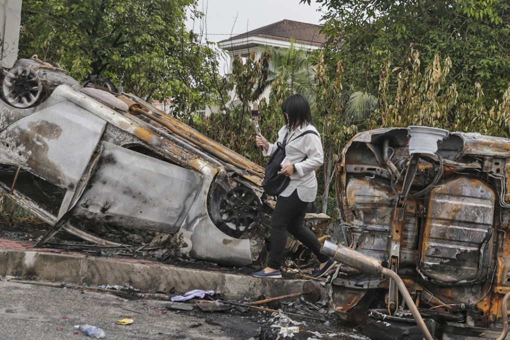 A burnt car that was flipped upside down during the riot at the Sri Maha Mariamman Temple in Subang Jaya, Selangor, outside Kuala Lumpur, Malaysia. Photo: EPA