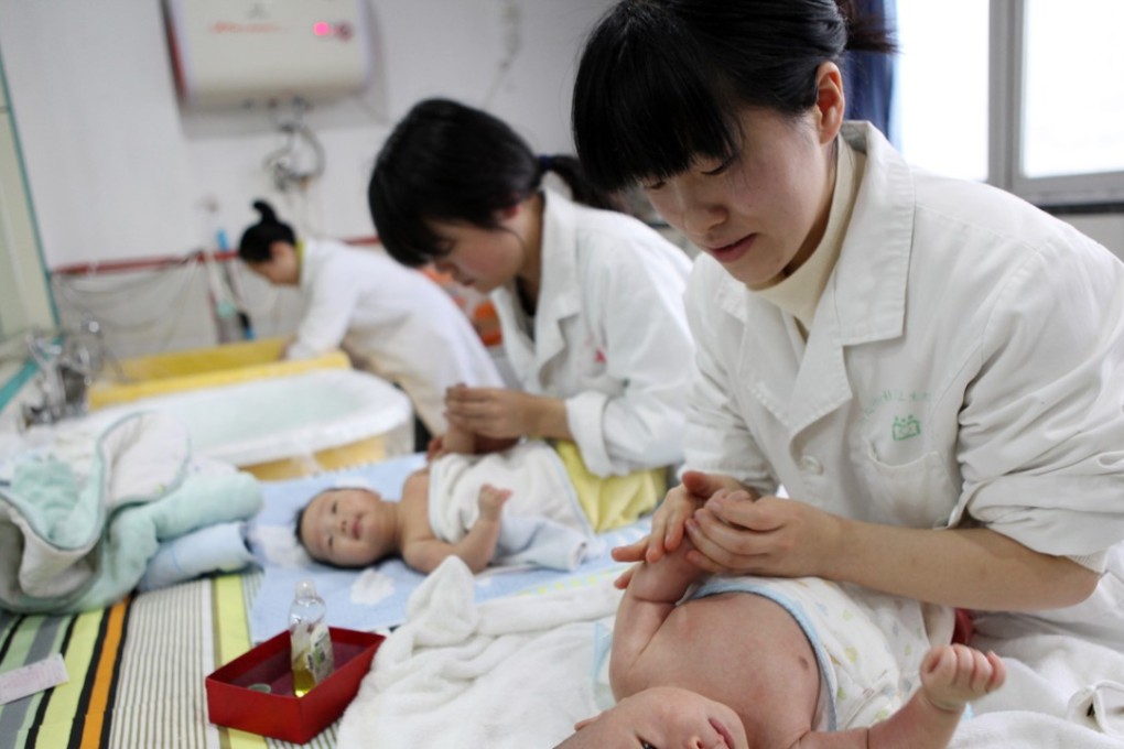 Nurses massaging babies at an infant care centre in Yongquan in Chongqing municipality in southwest China on December 15, 2016. Photo: AFP