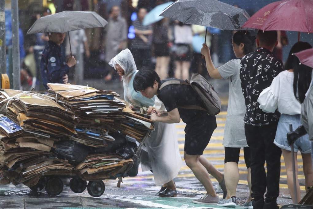 A young man helps an elderly woman push a trolley of cardboard sheets she collected for recycling during a rainy day in Hong Kong, in May 2017. A larger proportion of Hong Kong’s elderly than its working-age population live in public housing, a fact not reflected in the city’s poverty line calculations. Photo: Sam Tsang
