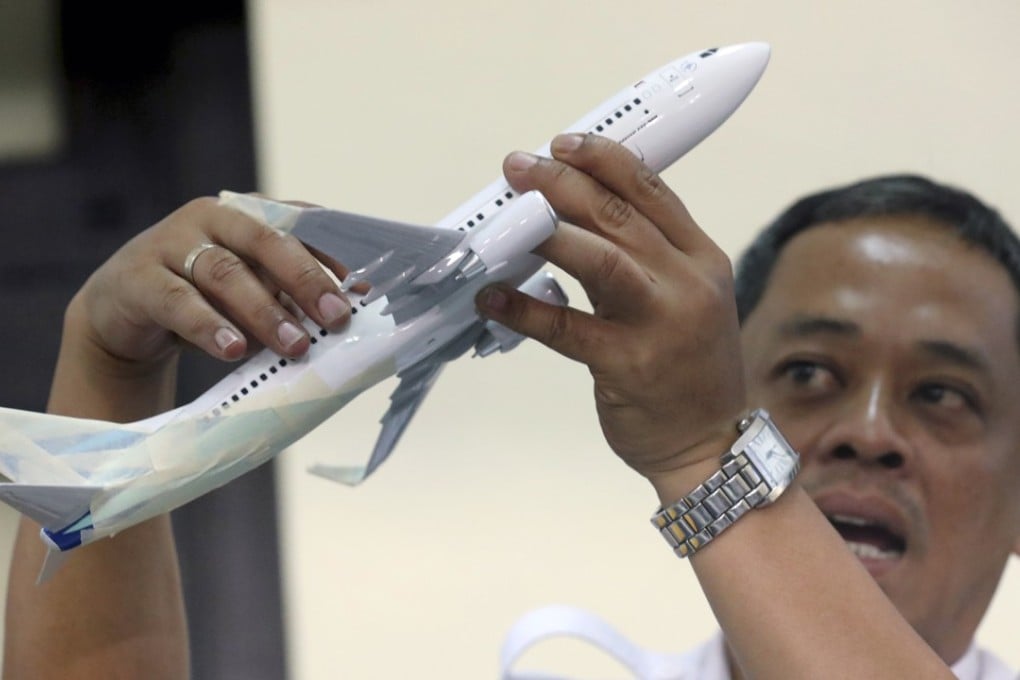 Indonesian National Transportation Safety Committee investigator Nurcahyo Utomo with a Boing 737 aircraft model. Photo: EPA