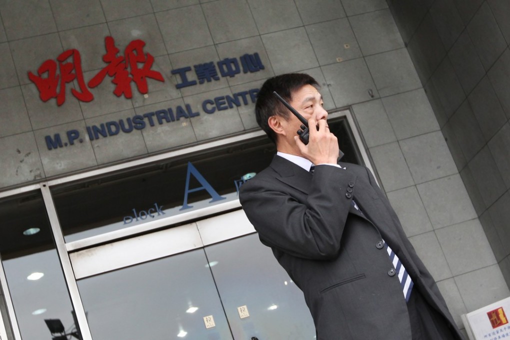 A security guard stands outside Ming Pao newsroom in Chai Wan. Photo: Handout