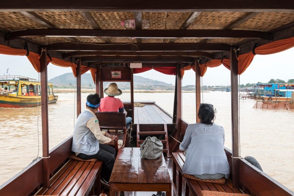 A tourist enjoys a private cruise tour with her guide on Tonle Sap Lake, Siem Reap, Cambodia. Publisher Rough Guides has launched a bespoke adventure travel service for older travellers. Photo: Alamy