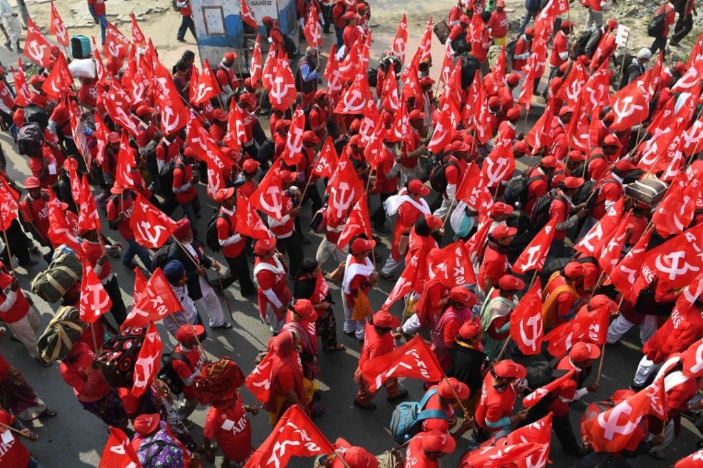 Farmers march holding aloft flags of the Communist Party of India (Marxist) and other leftist groups. Photo: AFP