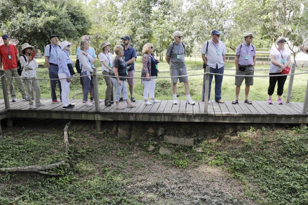 Tourists view mass graves of victims who died during the Khmer Rouge regime at the Choeung Ek Genocidal Centre, on the outskirts of Phnom Penh, Cambodia. Photo: EPA-EFE