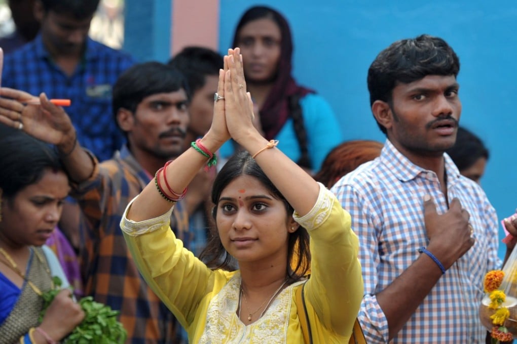 At the Chilkur Balaji Temple near Hyderabad, an Indian woman prays to Lord Balaji, known as the ‘Visa God’, to grant her wish to work in the US. Photo: AFP