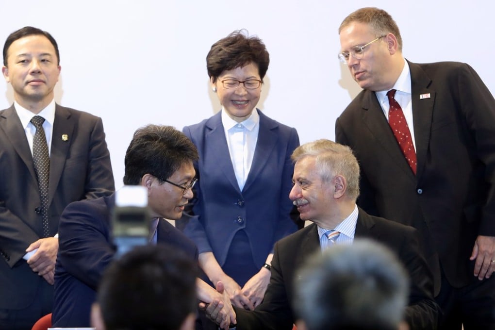 Christopher Chao, dean of engineering at HKU (left), and Fawwaz Habbal, executive dean for education and research at the Harvard School of Engineering and Applied Sciences, shake hands in front of Xiang Zhang, president and vice-chancellor at HKU (left), Chief Executive Carrie Lam, and Kur Tong, United States Consul General to Hong Kong and Macau. Photo: Winson Wong