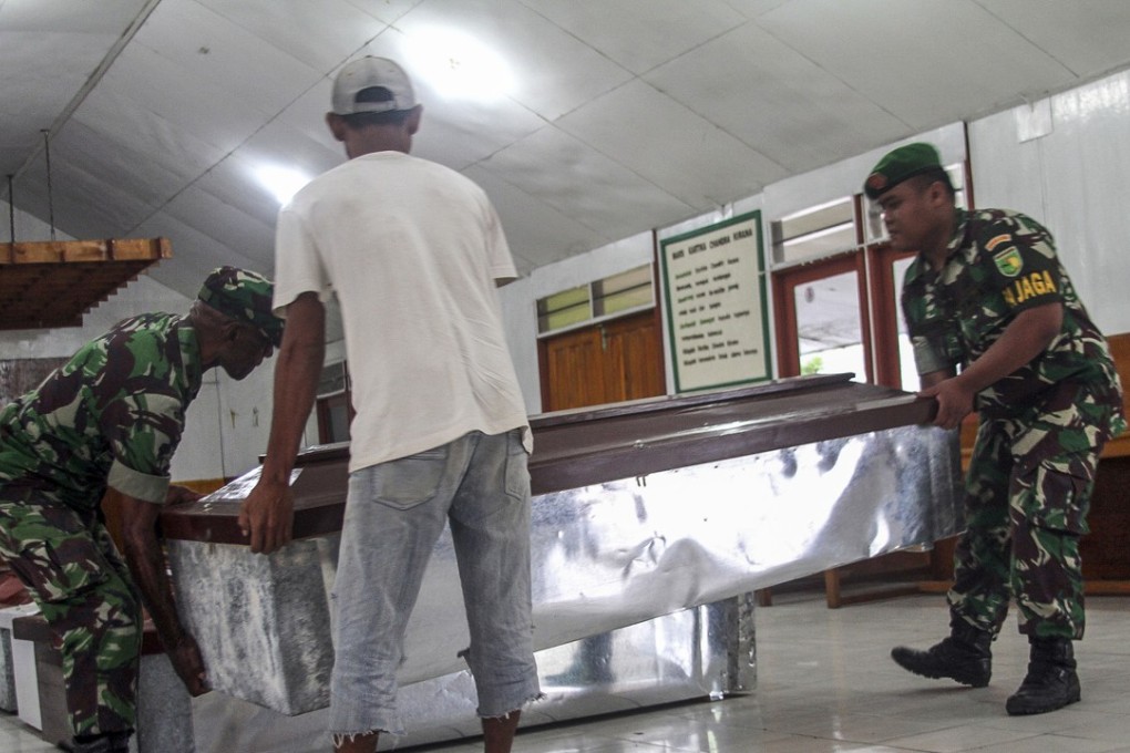 Indonesian military personnel prepare coffins for construction workers who were shot dead by suspected separatists. Photo: EPA