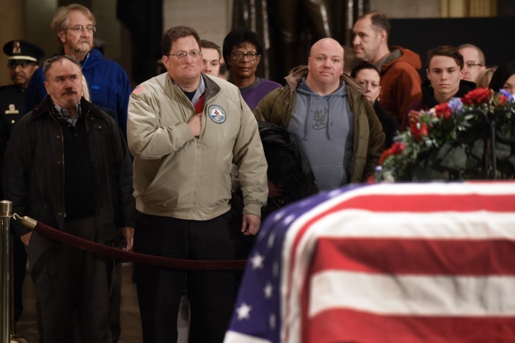 Visitors pay their respects in front of the flag-draped casket of former US president George H.W. Bush at the US Capitol Rotunda on December 3 in Washington. Photo: Abaca Press via TNS
