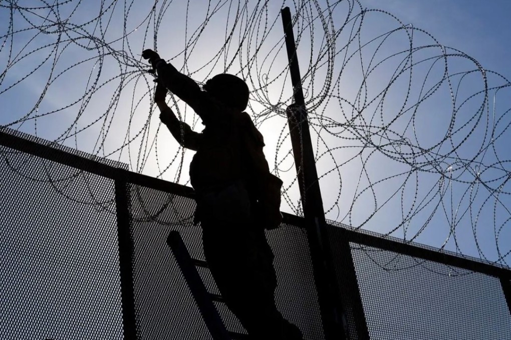 A US soldier hangs concertina wire on the US-Mexico border fence, in a file photo. Photo: US Marine Corps