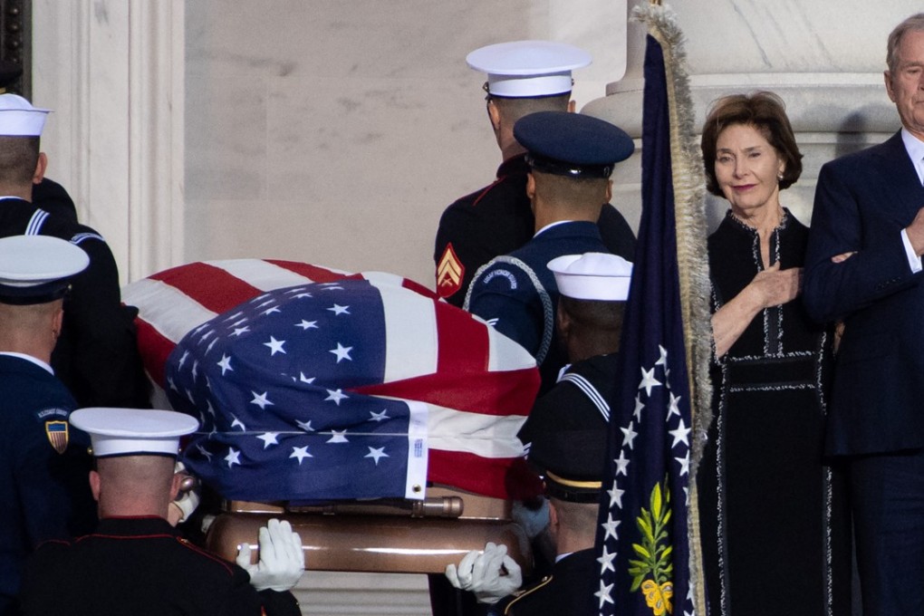 Former US president George W. Bush, and former First Lady Laura Bush, watch as the casket containing the remains of former US president George H.W. Bush arrive at the US Capitol in Washington on Monday. Photo: Agence France-Presse