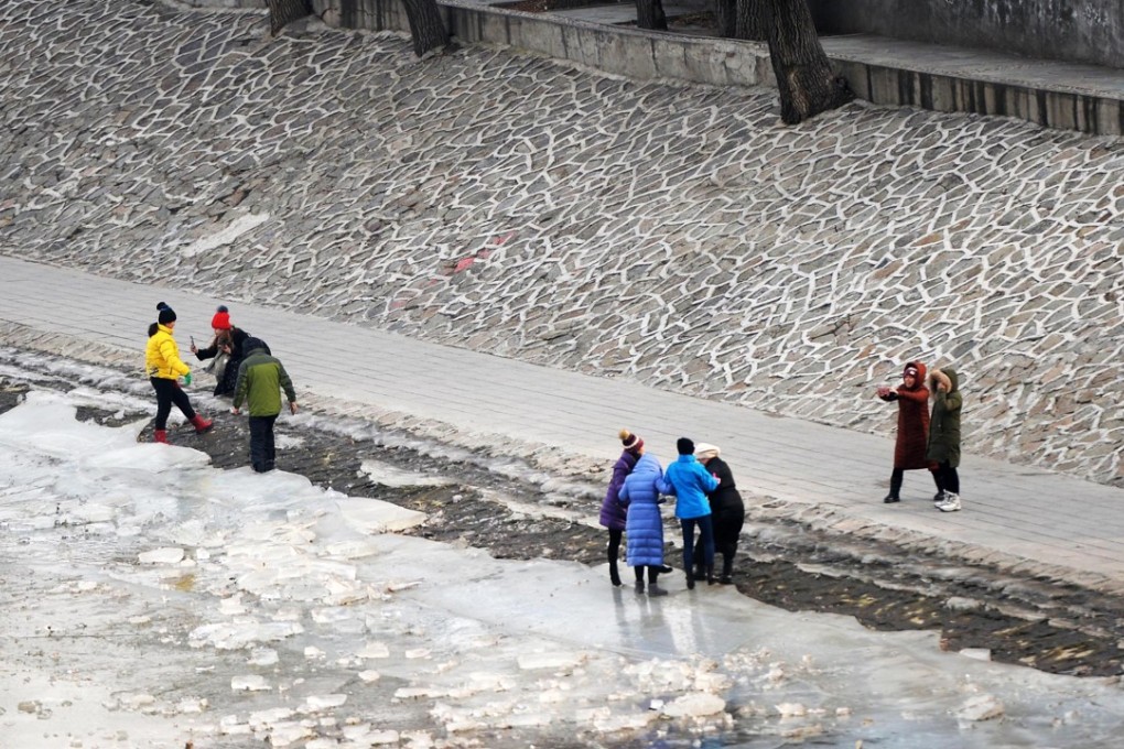 People pose for photos by the frozen Songhua River in Harbin, Heilongjiang. Photo: Xinhua